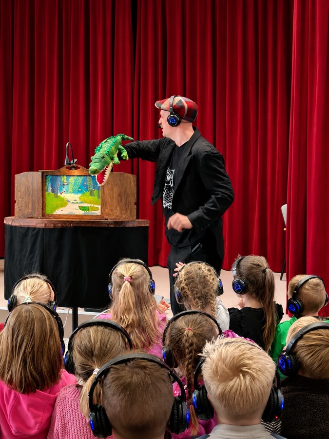 Kamishibai-voorstelling met koptelefoons: kinderen kijken naar het vertelkastje van A.vontura Silent Disco Theater